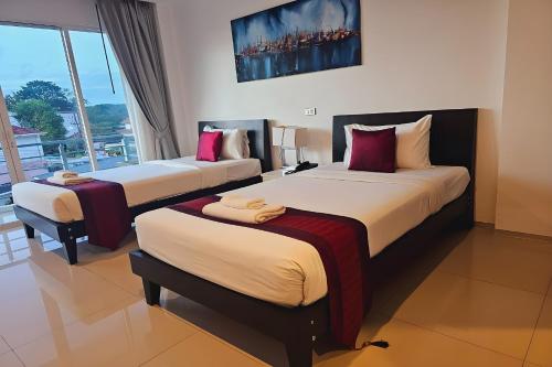Postel nebo postele na pokoji v ubytování One World One Home Naiharn Hotel