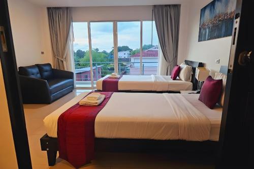 Postel nebo postele na pokoji v ubytování One World One Home Naiharn Hotel