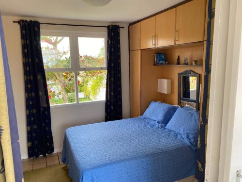 um quarto com uma cama azul e uma janela em Excelente casa de praia no Cachoeira do Bom Jesus em Florianópolis