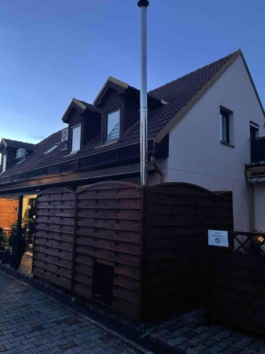 a house with a wooden fence in front of it at Ubytování U Synagogy Dobříš in Dobříš