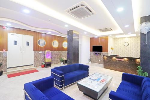 a lobby with two blue couches and a table at Hotel Amara Inn - Near Delhi Airport in New Delhi
