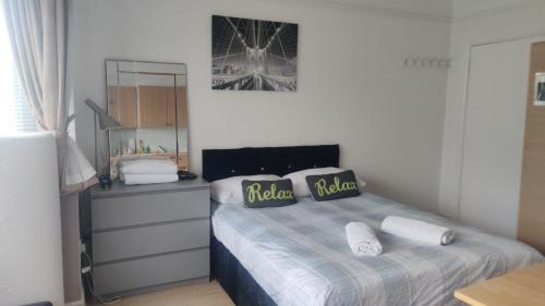 a bedroom with a bed with two pillows on it at Studio on Golders Green Road in London