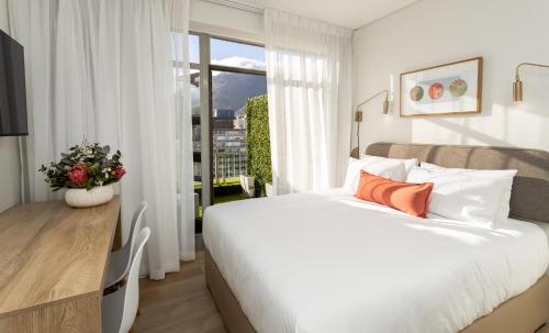 Un dormitorio con una gran cama blanca y una ventana en Habitat Aparthotel by Totalstay, en Ciudad del Cabo