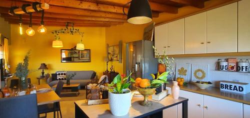 a kitchen with yellow walls and a table with flowers on it at VELANIDIA HOUSE in Rafina