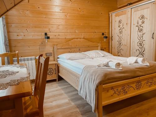a bedroom with a bed in a wooden room at Pokoje gościnne u Galusia in Mochnaczka Wyżna