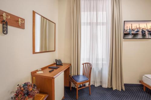 a hotel room with a desk and a bed at Hotel Europa in Brno