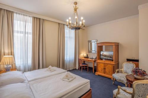 una camera d'albergo con un grande letto e una scrivania di Hotel Europa a Brno