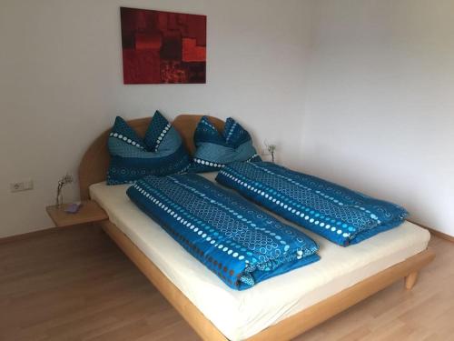 a bed with blue pillows on top of it at Ruhige schöne 2-Zimmer Ferienwohnung in Höchst