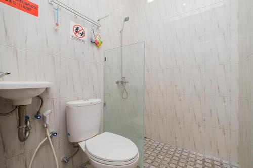 een badkamer met een toilet en een wastafel bij RedDoorz near Kampung Inggris Pare in Pare