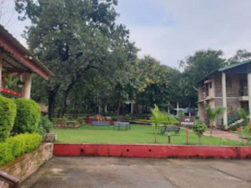 un parque con bancos y árboles y un edificio en MPT Jungle Camp, Panna, en Rājgarh