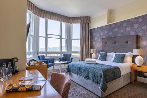 um quarto de hotel com uma cama e uma sala de estar em Windermere Hotel em Windermere