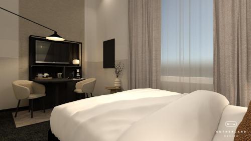 a bedroom with a bed and a desk and a television at Golden Tulip Keyser Breda Centre in Breda