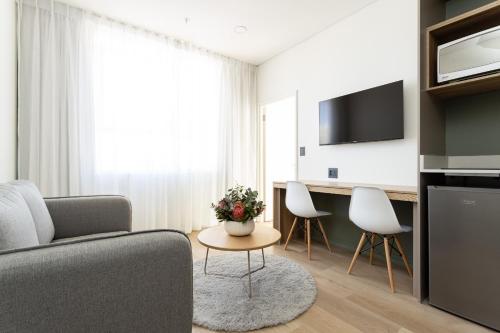 a living room with a couch and a table and chairs at Habitat Aparthotel by Totalstay in Cape Town