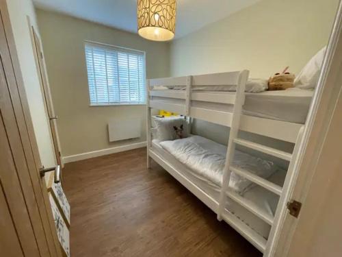 a bedroom with two bunk beds and a window at Pass the Keys Modern Family Friendly Flat with Parking in Rickmansworth