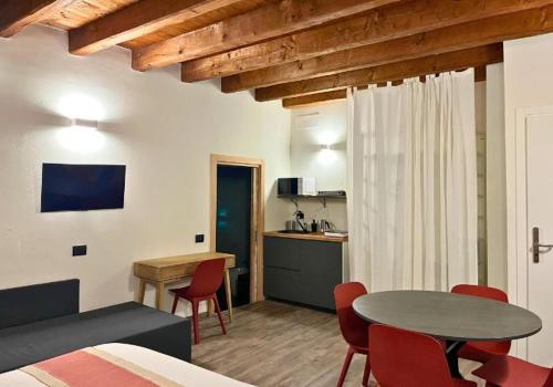 une chambre avec une table et des chaises ainsi qu'une cuisine dans l'établissement ANNAMA Coliving, à Brescia