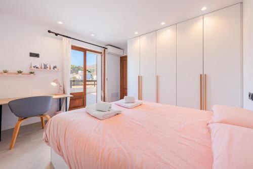 a bedroom with a bed with a desk and a chair at Villa Ana to rent in Puerto Pollensa by JS Villas in El Port
