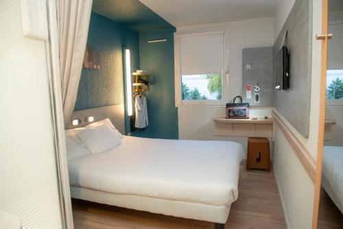 a small bedroom with a white bed and a window at Ibis Budget Le Havre Les Docks in Le Havre