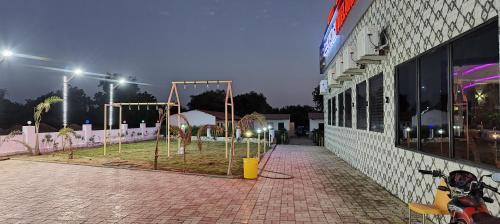 a motorcycle parked in front of a building at night at Neelkanth Hotel and Restaurant in Dabhoi