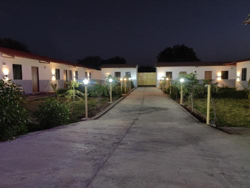 a driveway leading to a row of houses at night at Neelkanth Hotel and Restaurant in Dabhoi