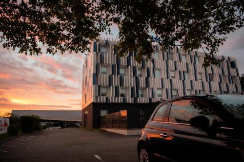 a car parked in a parking lot in front of a building at Ibis Budget Le Havre Les Docks in Le Havre