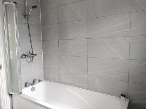 a bathroom with a shower with a white tub at Bright Spacious Twin Room, next to Underground Station in Abbey Wood