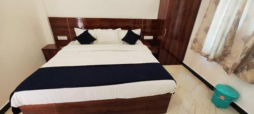 - une chambre avec un lit et une couverture noire et blanche dans l'établissement HOTEL KANAK KUTEER, à Ayodhya