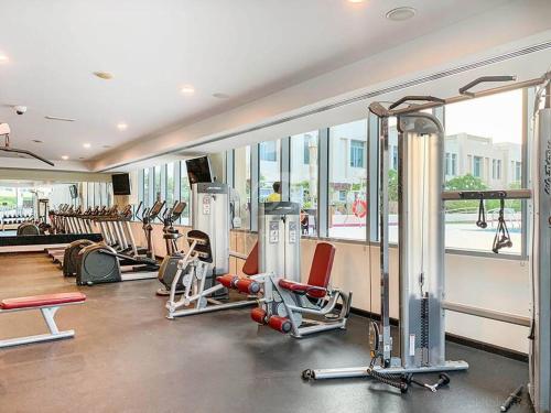 a gym with a bunch of equipment in a room at Lakeside Bliss Home in Dubai