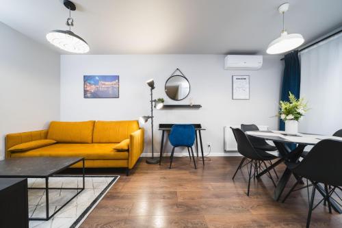 sala de estar con sofá amarillo y mesa en Apartament z tarasem oraz podziemnym parkingiem en Cracovia