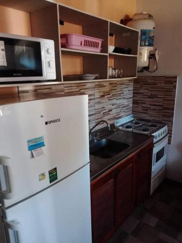 una cucina con frigorifero bianco e forno a microonde di Mar de Atlantis a Mar de Ajó