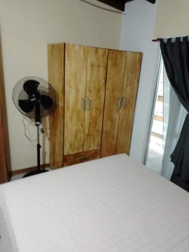 a bedroom with a bed and a wooden cabinet at Mar de Atlantis in Mar de Ajó