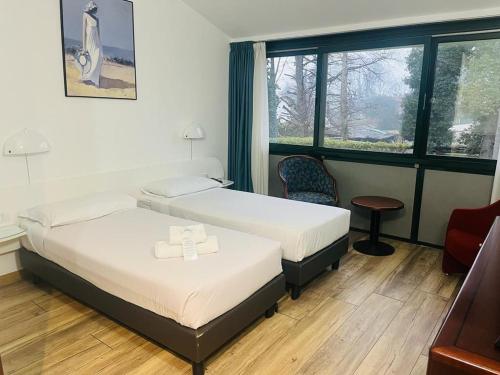 a hotel room with two beds and a window at Green Hotel in Vergiate