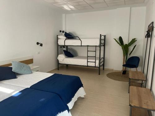 a bedroom with a bed and two bunk beds at La Antigua Editorial in Pozuelo de Zarzón