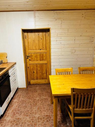 a kitchen with a wooden table and a wooden door at Scout valley in Totoriškis