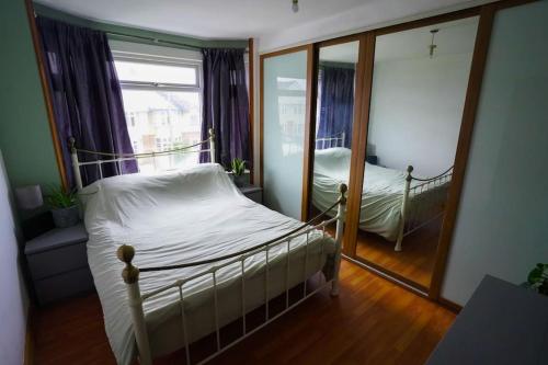 1 dormitorio con cama y espejo en 3 Bedroom Home in the Dale’s, Very close to Ipswich town centre. en Whitton
