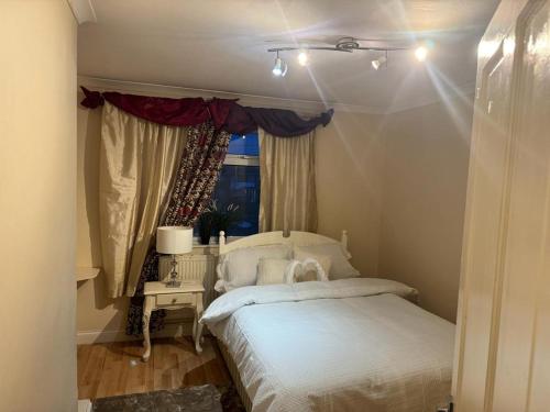una camera con un letto bianco e una finestra di EL MET GLOBAL APARTMENT a Slades Green