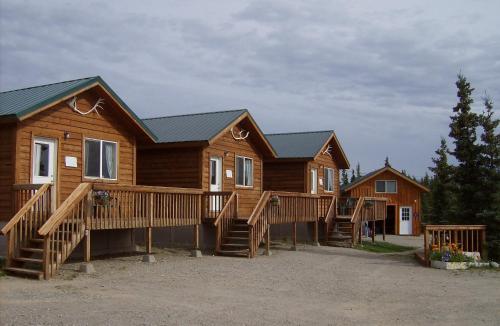 eine Reihe von Blockhäusern auf einem Parkplatz in der Unterkunft Alaskan Spruce Cabins in Healy