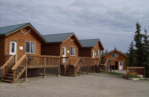 a row of log homes in a parking lot at Alaskan Spruce Cabins in Healy