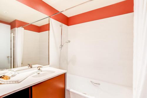 W łazience znajduje się umywalka i lustro. w obiekcie Hotel ParKest w mieście Genas