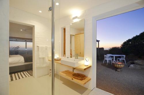 a bathroom with a tub and a sink and a mirror at !Khwa ttu in Swartwater
