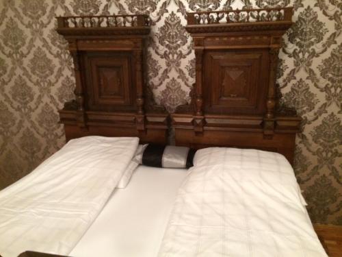 a bed with a wooden headboard with ansicsnsics at Apartament Sophie in Sibiu