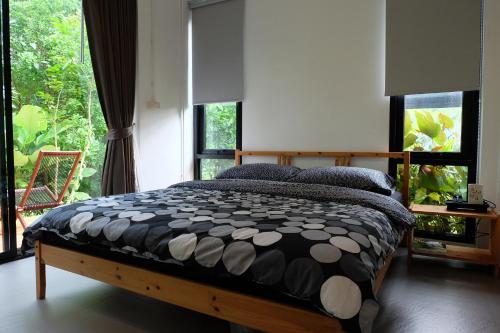 a bedroom with a bed and a large window at Rivercreek Estate in Kaeng Krachan