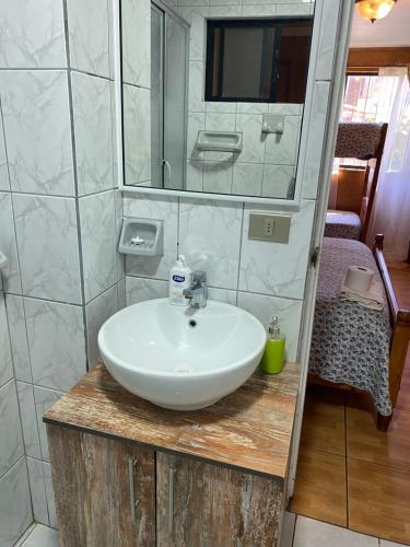 y baño con lavabo blanco y espejo. en Hotel San Juan, en Coquimbo
