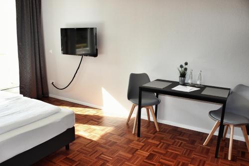 ハイデルベルクにあるHometown-Apartmentsのテーブル、椅子、テレビが備わる客室です。