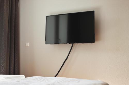 TV de pantalla plana colgada en la pared en Hometown-Apartments en Heidelberg