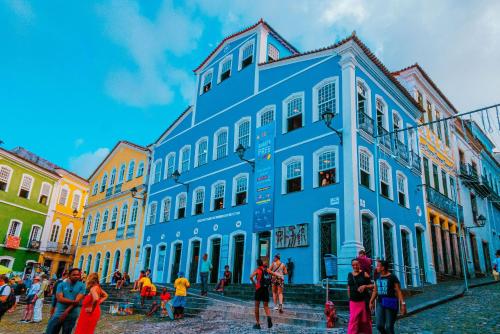 un groupe de personnes debout devant un bâtiment bleu dans l'établissement Casarão de época , Stúdios até 6 hóspedes., à Salvador