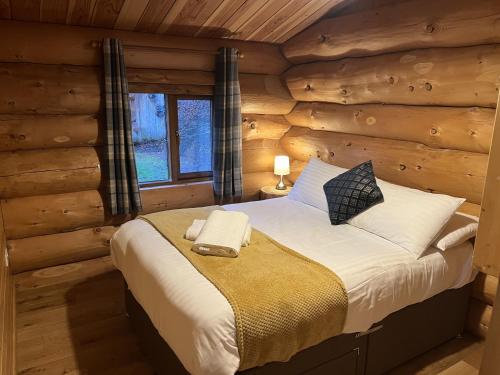 a bedroom with a bed in a log cabin at Mountain Edge Resort Lodge 3 with Hot Tub in Church Stretton
