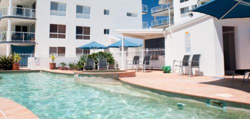 a swimming pool in front of a apartment building at Bargara Blue Resort in Bargara