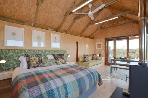a bedroom with a bed in a room with wooden ceilings at !Khwa ttu in Swartwater