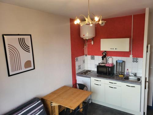 - une petite cuisine avec une petite table, une table et un comptoir dans l'établissement Studio reposant et calme, à Agen