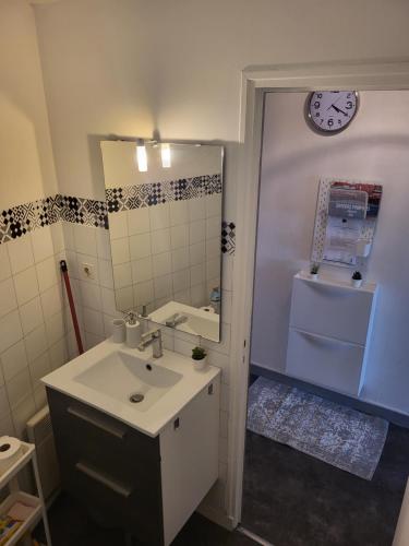 une salle de bain avec un lavabo et un miroir dans l'établissement Studio reposant et calme, à Agen